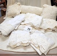 Full view of all pieces in the set: bedspread, 3 crochet pillows (2 square, 1 bolster), 2 pillow shams, flat sheet, and pillowcases arranged for display.