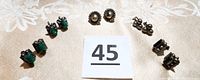 Five pairs of vintage Mexico silver screw back earrings arranged on a beige fabric background with an auction number card '45'. Visible designs include starburst, green stones, onyx, and cluster shapes.