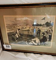 Front view of framed vintage tennis print depicting a historic outdoor tennis match with spectators and sailboats in the background.