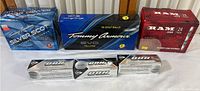 Photo of multiple boxes of golf balls on a table, showing Tommy Armour Silver Scot, Tommy Armour Yellow, Ram, and Callaway Chrome Soft brands.