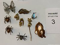 Photo showing all eleven vintage animal-themed brooches arranged on a white background.