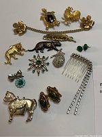 Top-down view of collection displaying all vintage jewelry pieces including animal pins, rhinestone brooches, earrings, and rhinestone comb.