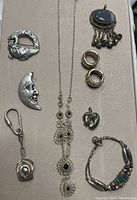 Overview of the vintage jewelry collection showing owl brooch, moon face brooch, necklace, earrings, heart pendant, keychain, bracelet and oval pendant.