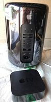 Front view of Apple Mac Pro cylinder tower and Apple TV unit