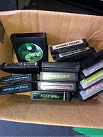 Overhead view of cardboard box containing assortment of Atari 2600 cartridges