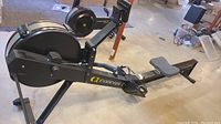 Side view of Concept2 RowerG rowing machine on concrete floor showing frame, seat, footrests and flywheel