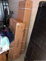 Stacks of branded cardboard shipping boxes for a Bells of Steel Reverse Hammer Machine, white strapping visible