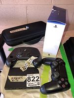 Overhead view showing two controllers, Steam Link box, carrying case, PlayStation box