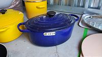 Front view of blue oval Dutch oven with lid and side handles