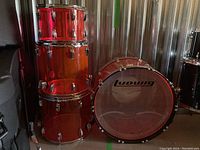 Overall view of bass drum and three tom shells in translucent red acrylic