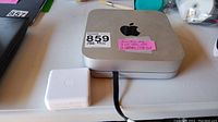 Silver Apple Mac Mini M1 top view with auction stickers and pink note indicating specs
