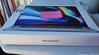 Sealed retail box with MacBook Pro branding and lot sticker