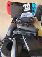 Assorted items including docked console, AC adapter and controllers