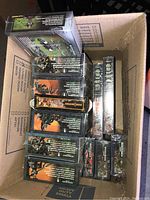 Cardboard box filled with multiple sealed Citadel Warhammer 40,000 Necron model boxes arranged inside.