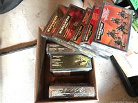 Eight sealed model kit boxes laid in a cardboard tray