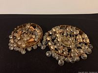 Top view of two tiered brass swag chandeliers with multiple clear orb crystal drops visible.