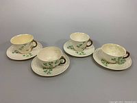 Three short teacup and saucer sets with shamrock decoration and gold trim