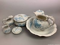 Five-piece blue transferware vanity set including pitcher, basin, chamber pot, soap dish, and toothbrush holder, showing overall arrangement.