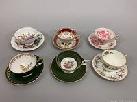 Overview of all six bone china teacup and saucer sets arranged on a flat surface.