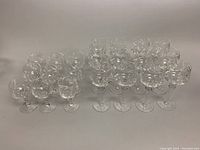 Overview of 21 vintage Bohemian cut crystal hock wine goblets arranged on a surface, showing the set size and general condition.
