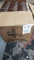 Photo of sealed moving box labeled 'Golden Gate Moving & Storage' filled with vinyl records, taped shut, showing exterior condition and scale of the lot.