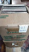 A full cardboard box filled with vinyl record albums, labeled for transport, showing quantity and condition.