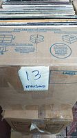 Sealed cardboard box containing vinyl LP records with handwritten lot number '13' on label.