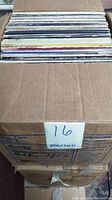 Box packed with approx. 100 vinyl LP records, showing condition and quantity.