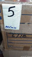 Photo of a sealed cardboard box labeled with number '5' and 'MaxSold' indicating it contains part of the lot.