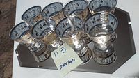 Set of 8 mid century lowball whiskey glasses with etched gold and silver centaur Greek Roman designs displayed on reflective surface.