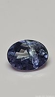 Close-up view of the oval cut sky blue tanzanite gemstone taken on a plain background to highlight color and inclusions.