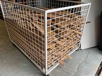 Boards piled in large white metal wire cage