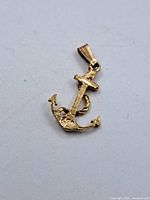 Front view of the 10K gold anchor pendant showing the anchor shape and rope detail.