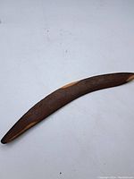 Full view of the wooden boomerang showing its curved shape and the two tone wood ends.