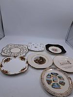 Six assorted porcelain plates displayed together on white background with photo showing overall lot contents and condition.