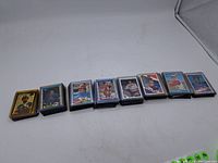 Eight stacks of assorted hockey and baseball cards laid out in a row