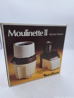 Front of box showing Moulinette II Kitchen Genius branding and image of food processor unit.