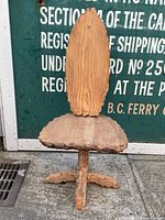 Front view of vintage wooden carved chair showing tall oval backrest and carved seat