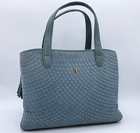 Front angled view of the slate blue Bally quilted suede handbag with gold-tone B logo and leather fringe tassel, showing overall design and handles.