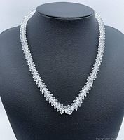 Front view of the graduated crystal bead necklace on a black display bust showing bead size variation and clasp.