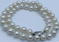 Top close-up view of the genuine pearl necklace showing the size and shape of the pearls and the silver bean clasp closure.