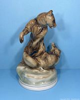 Front view of antique porcelain sculpture showing two fighting bears on a rocky base.
