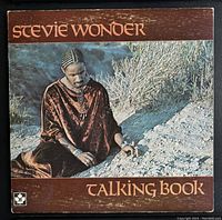 Front cover of the Stevie Wonder Talking Book 1972 vinyl album showing artist name and album title with image of artist.