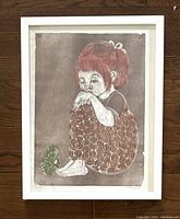 Framed color woodcut print of a young girl with a frog near her feet, showing overall condition and framing