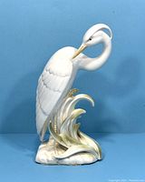 Front view of the white heron porcelain bookend with details on feathers, beak, and base showing gold accents.