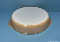 Bottom view of the round peach lustre baking dish showing the smooth base and peach-colored exterior.