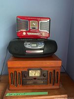 General view of all three radios stacked against a blue wall.