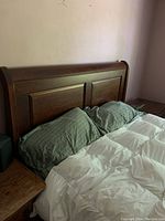 Cherry brown wooden headboard with panel detail and bedding