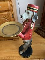 Full side view of dog butler figurine standing upright holding a round tray.