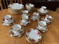 Overhead view showing stacks of dinner plates, bowls, luncheon plates, tea plates, teacups, and saucers spread across table.